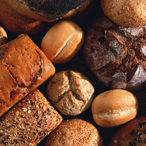 An assortment of baked breads; rye, white, wholegrain. All are of differing loaf shapes.